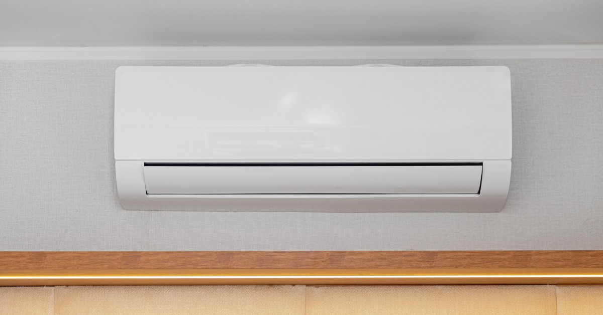  A close-up view shows a white mini split air conditioner attached to a white wall. The unit is not turned on.