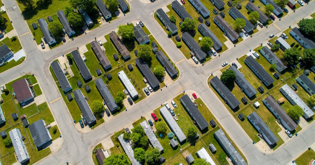 An aerial view of countless houses beside one another on green plots; each patch of green has ten houses placed on it.