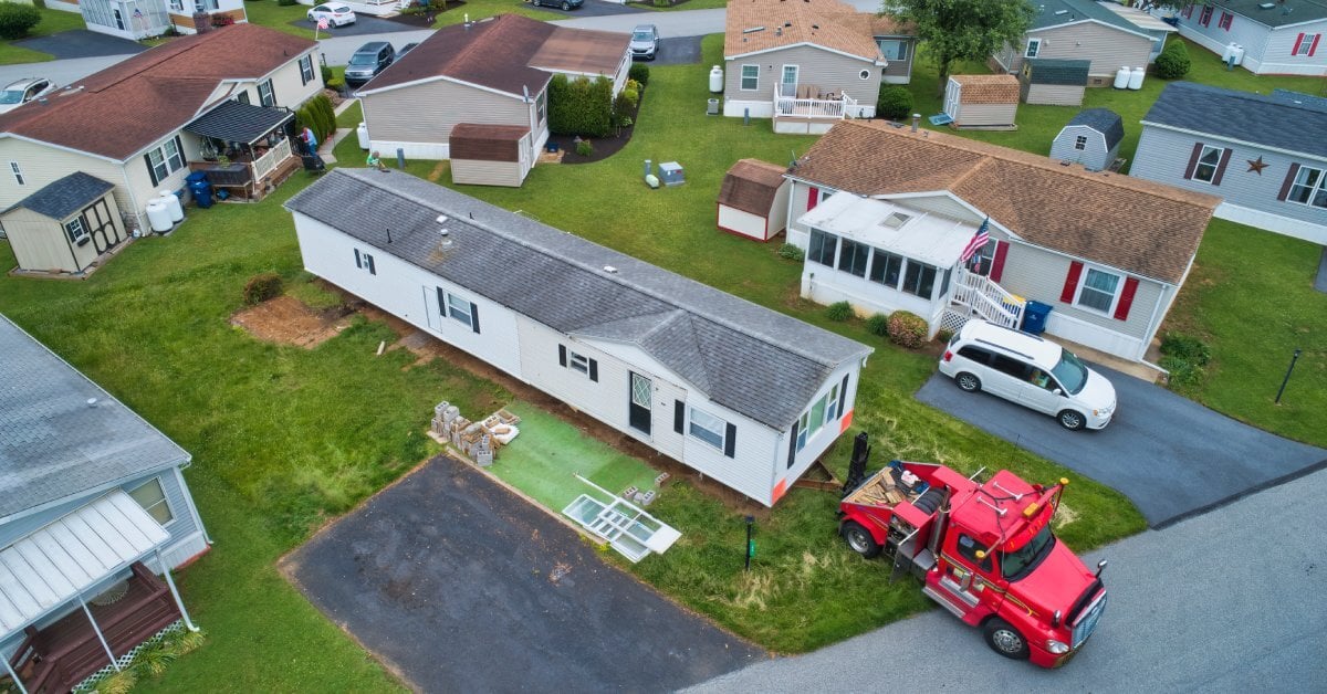 An ariel view of a neighborhood with numerous manufactured homes of different shapes. A towing truck sits outside of one.